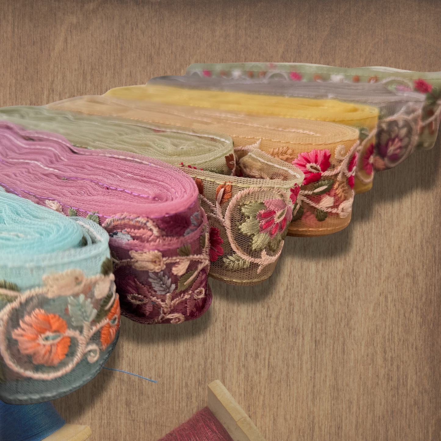 Tresa Embroidered Lace in different colours on a wooden background