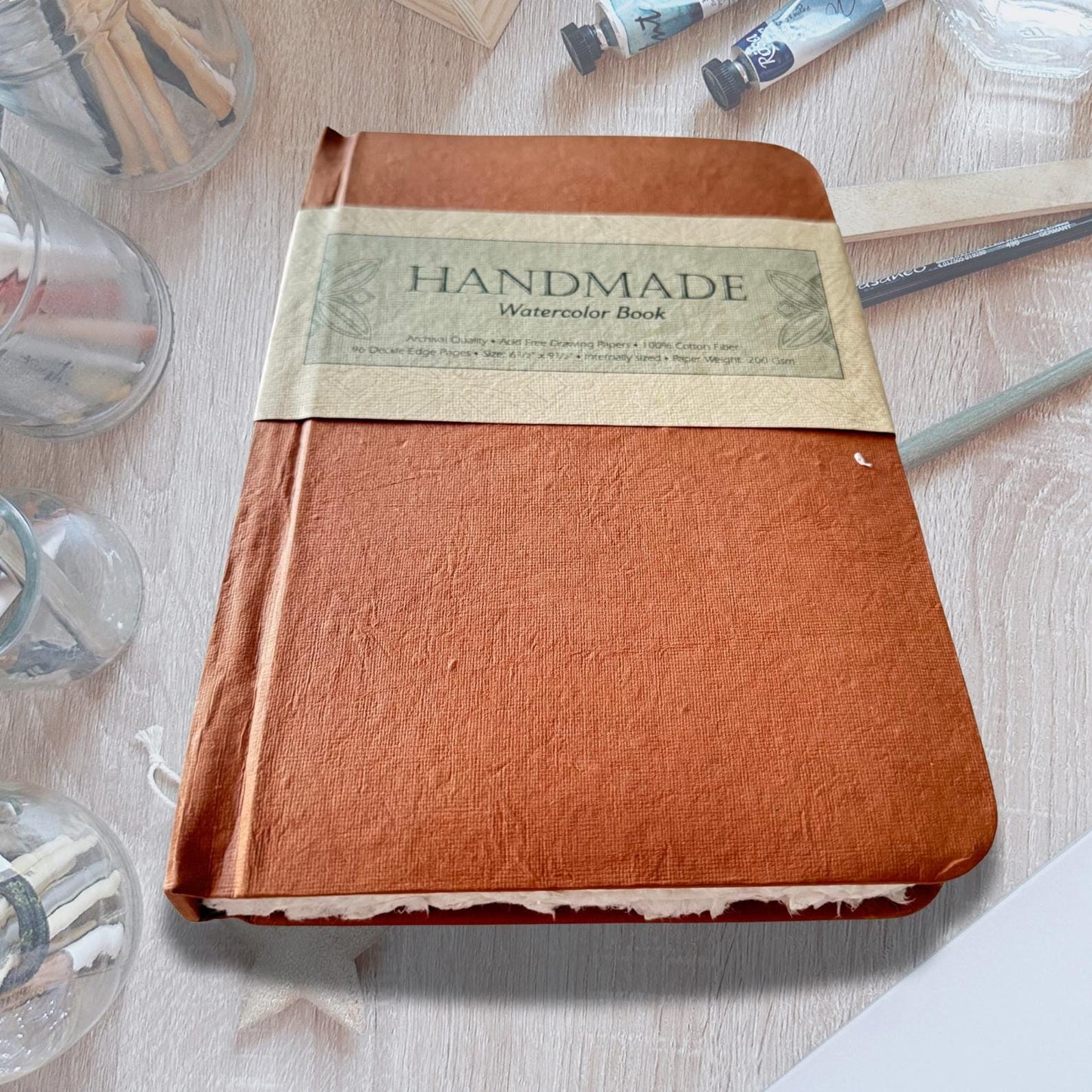Watercolour Colouring Book on an asthetic table with painitng brushes and water color paint.