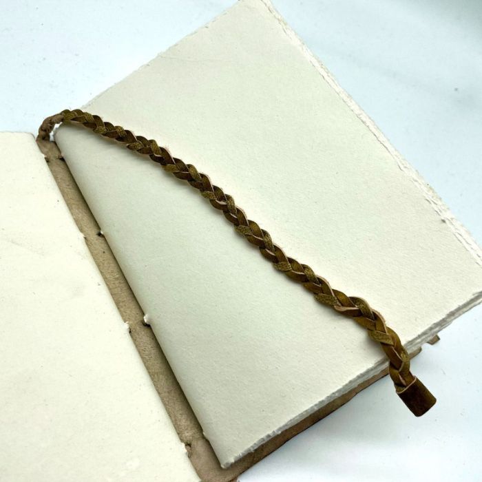 Full grain leather journal comes with an attached braided leather bookmark.