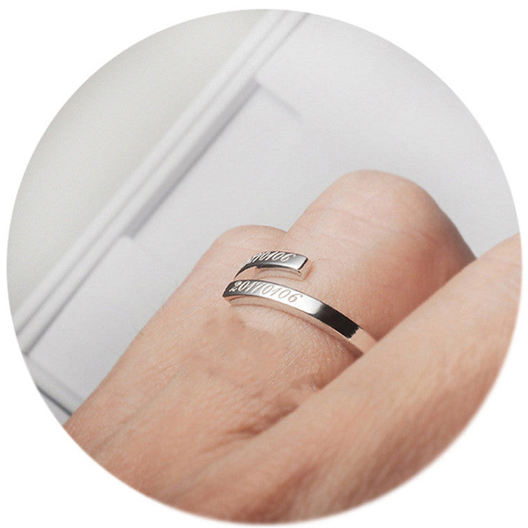 A person wearing the Giselle personalised name ring in silver with engraving on it. 