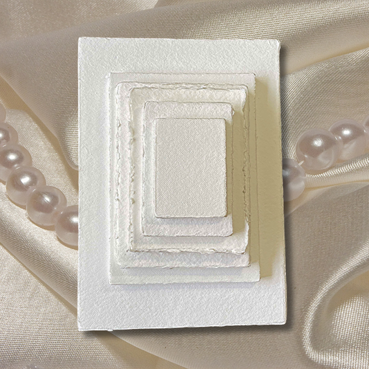 300 gsm different sizes stacked on a cream satin background