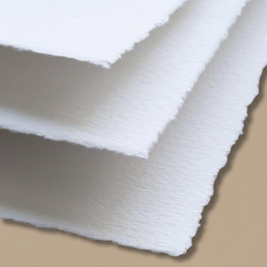 Close-up of stacked white 250 GSM handmade cotton rag paper showing natural rough deckle edges and soft cotton fibre texture, ideal for wedding invitations, calligraphy and watercolour painting