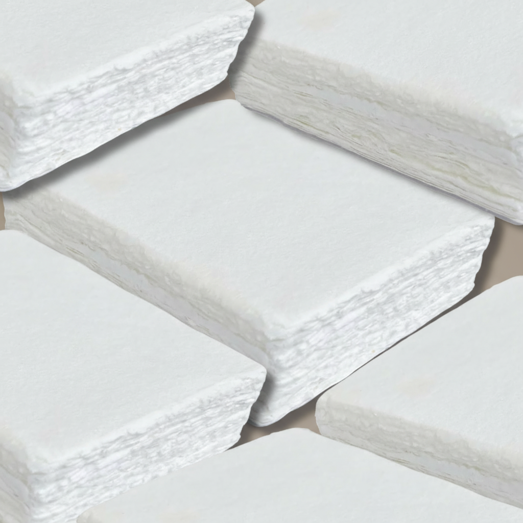Stacks of white 300 GSM handmade cotton rag paper with natural deckle edges on taupe background, available in A4, A5 and card sizes for DIY wedding stationery.
