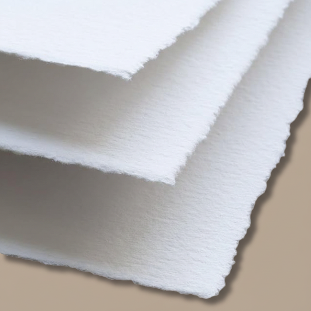 Close-up of stacked white 300 GSM handmade cotton rag paper showing natural rough deckle edges and soft cotton fibre texture, ideal for letterpress wedding invitations, calligraphy and watercolour painting, Australia