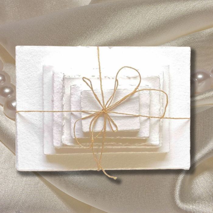 300 gsm different sizes stacked on a cream satin background tied with jute string