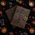 Decorative leather book with gemstone accents on a dark background with candles and flowers