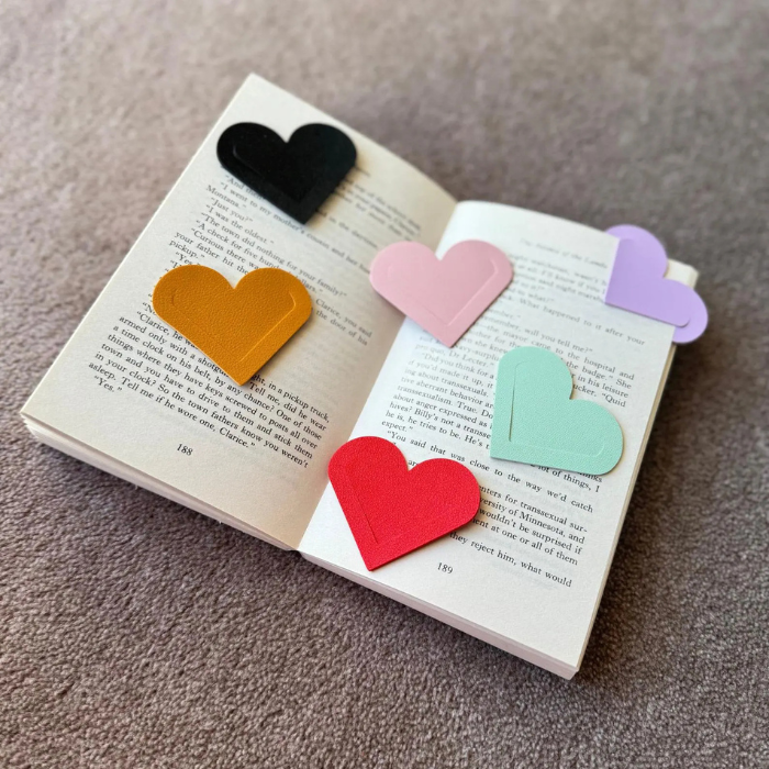 Heart corner bookmark set with black, pink, lavender, mint and red heart tags on book page.