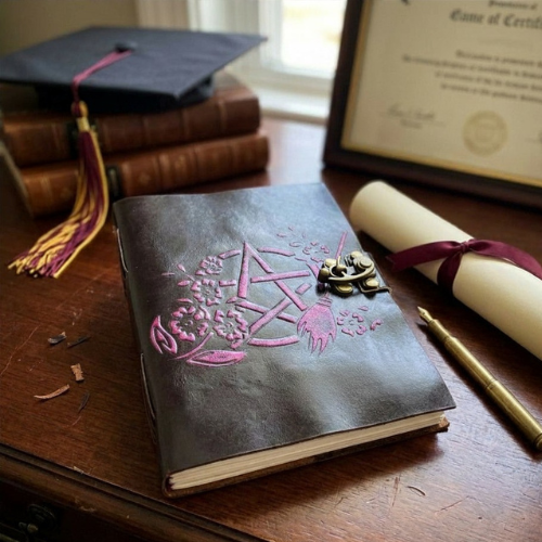 Dark leather journal with purple Celtic knot design and brass clasp on front cover