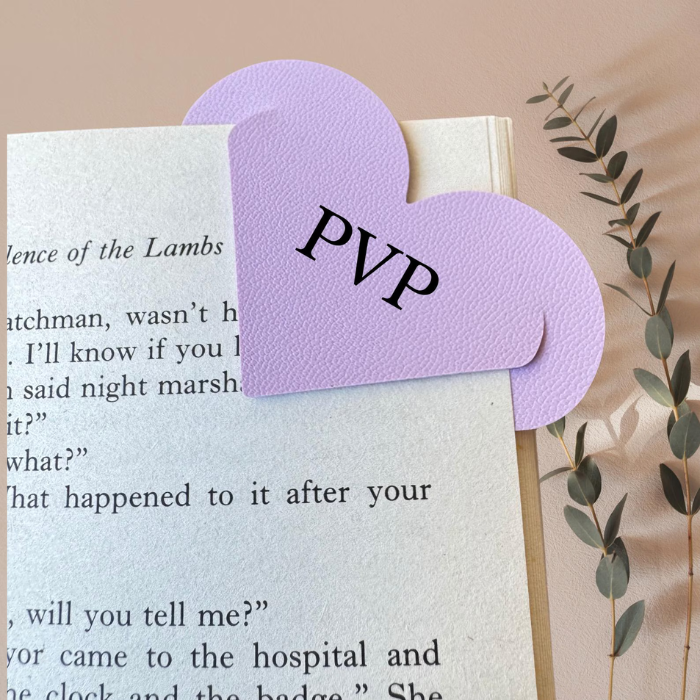 Lavender heart corner bookmark with bold letters on the tab, partially covering a book page.