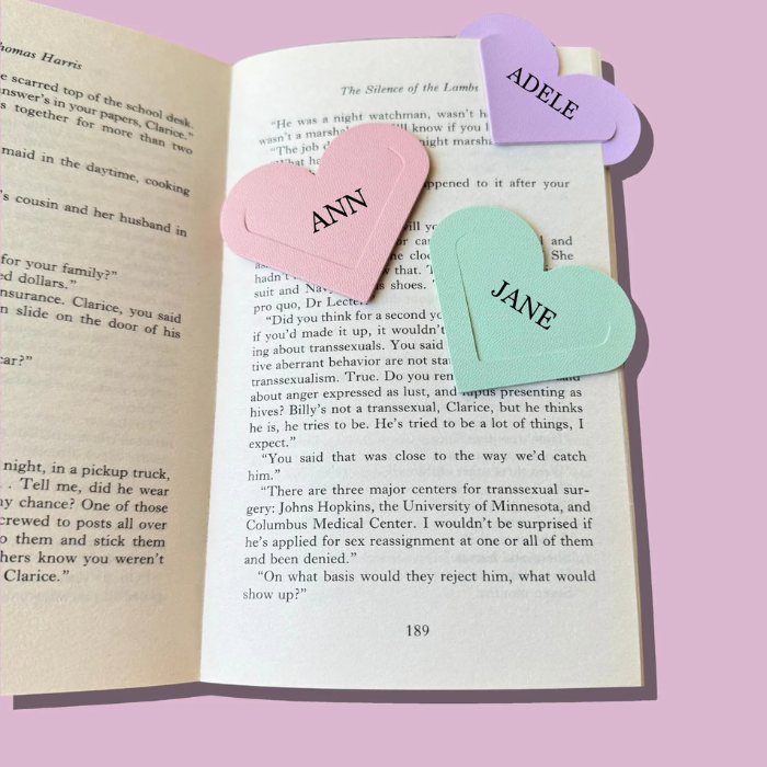 Heart corner bookmark set with light pink and teal heart tags at book corners over printed text.