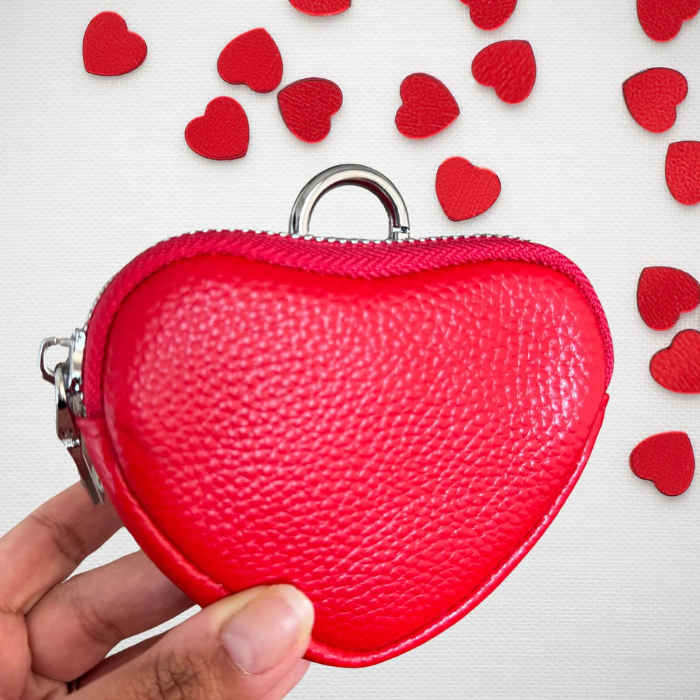 A person holding Heart coin purse keychain in red 