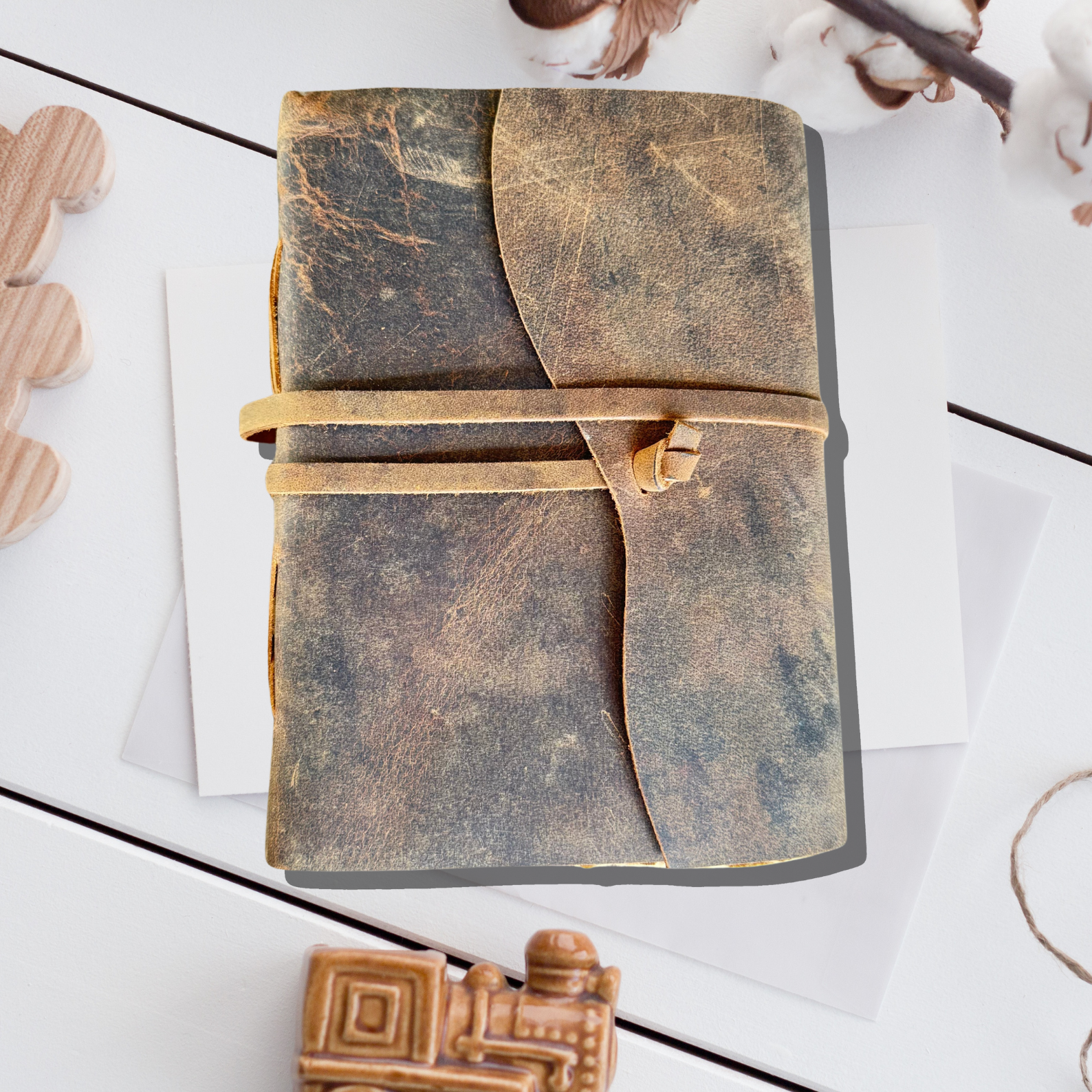 Leather Notebook Personalized - a leather journal on an asthetic white background with a few wooden pieces on its side