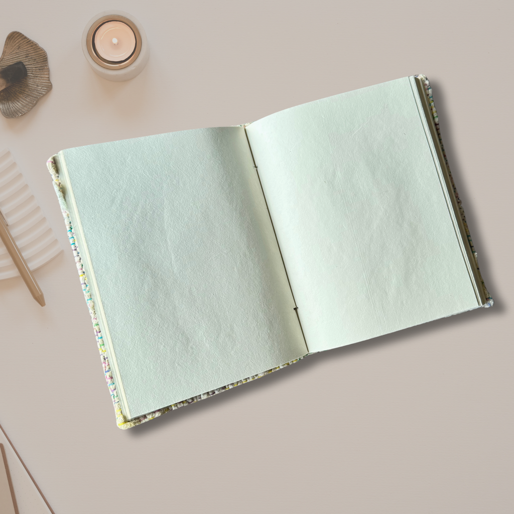 Open silk yarn notbook on an asthetic background with a candle burning on the side
