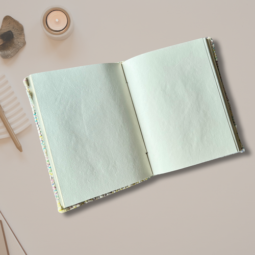 Open silk yarn notbook on an asthetic background with a candle burning on the side
