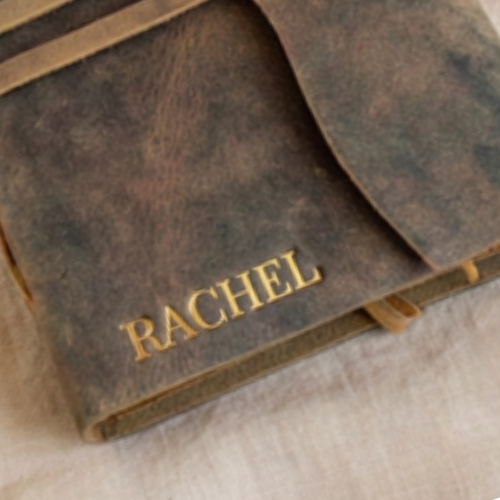 Close-up of gold embossed name RACHEL pressed into premium handmade leather journal cover — custom embossed leather bound journal Australia