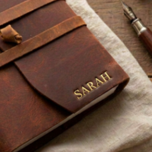 Close-up of embossed leather journal with gold personalised name SARAH — premium leather bound journal, perfect anniversary gift